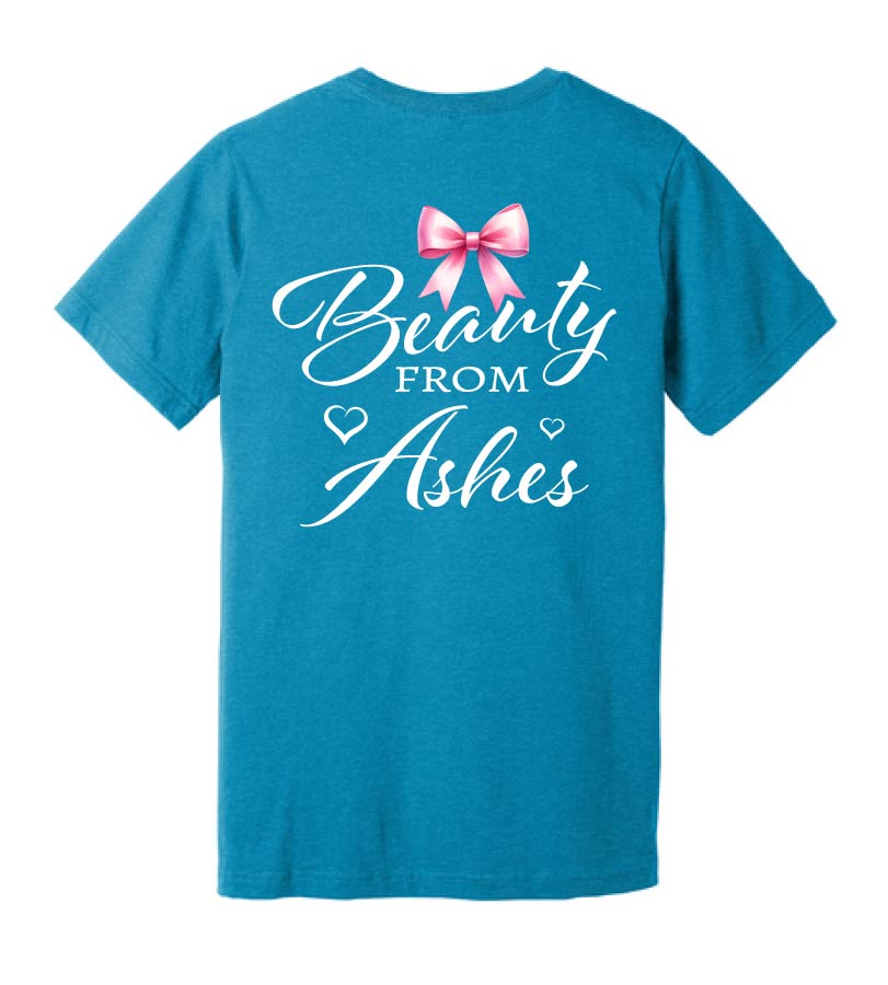 A blue t-shirt with the text 'Beauty from Ashes' written on the back, accompanied by a graphic of a bow.