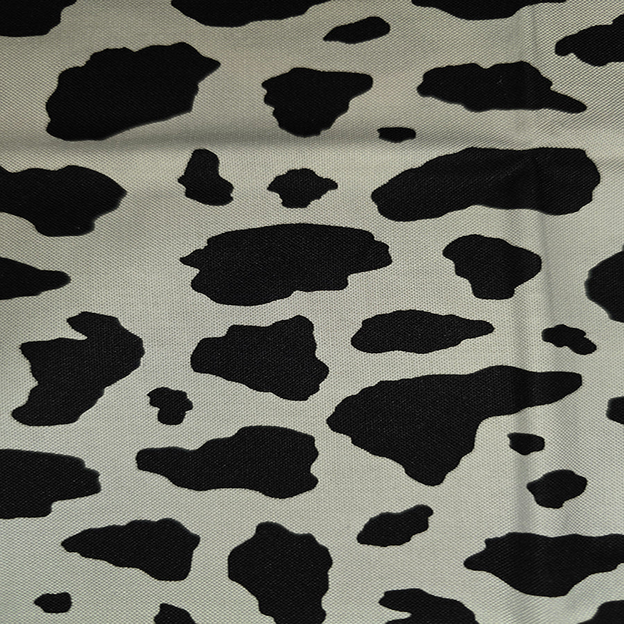 Black cow print pattern on a beige background