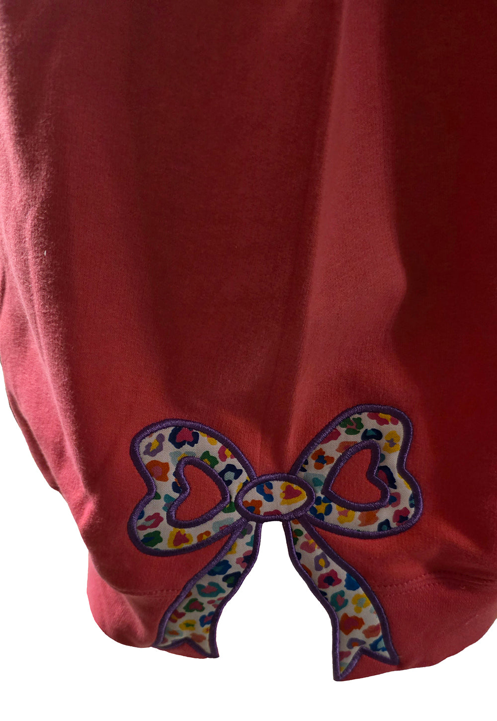 Close-up of a colorful bow design on a red fabric background