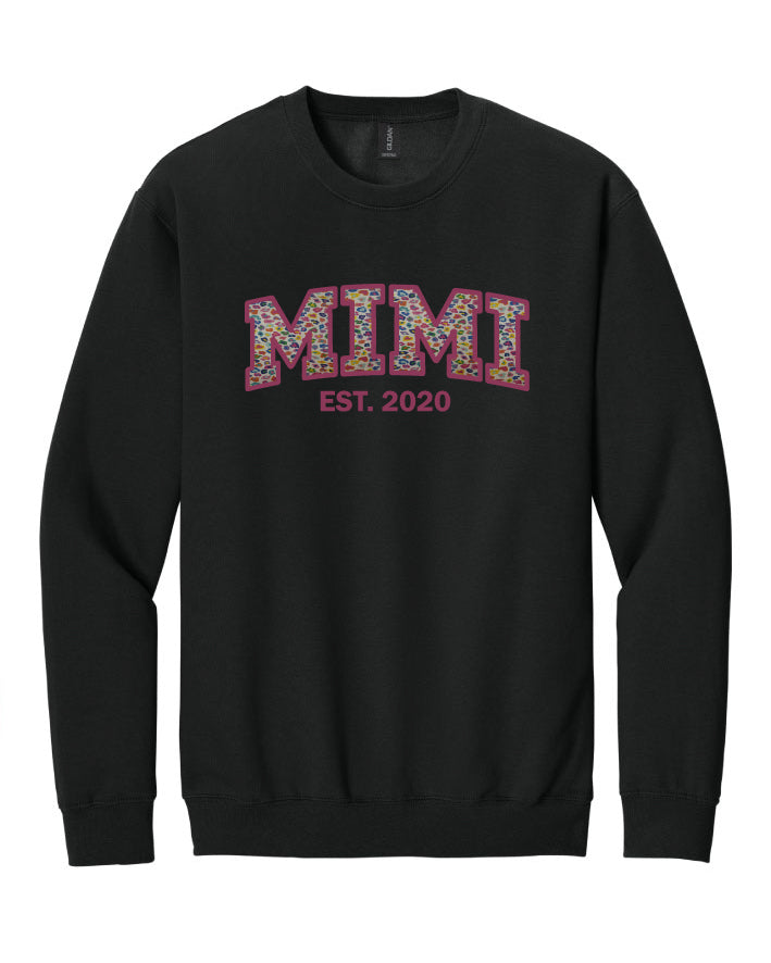Black sweatshirt with 'MIMI EST. 2020' text on a white background