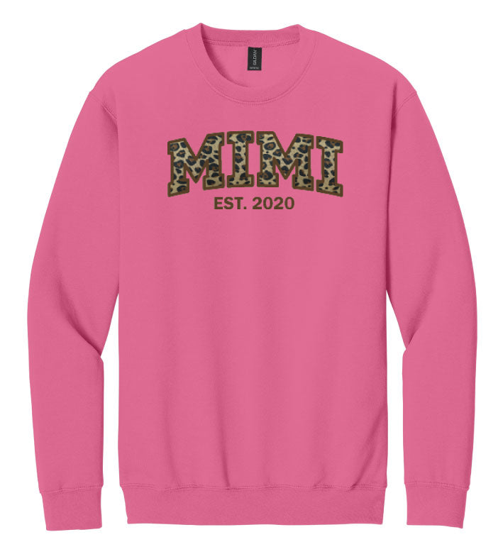 Pink sweatshirt with 'MIMI EST. 2020' text on a white background