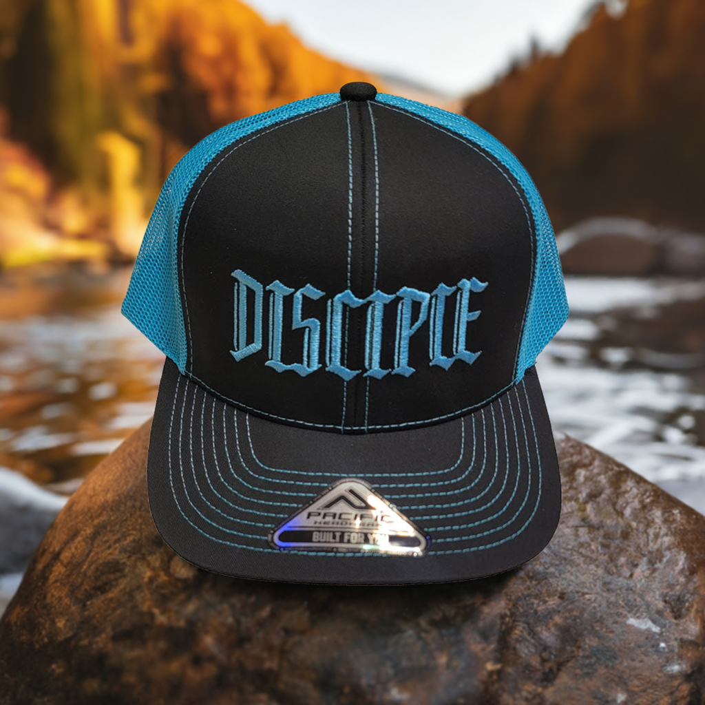 Neon blue Disciple Hat sitting on a rock